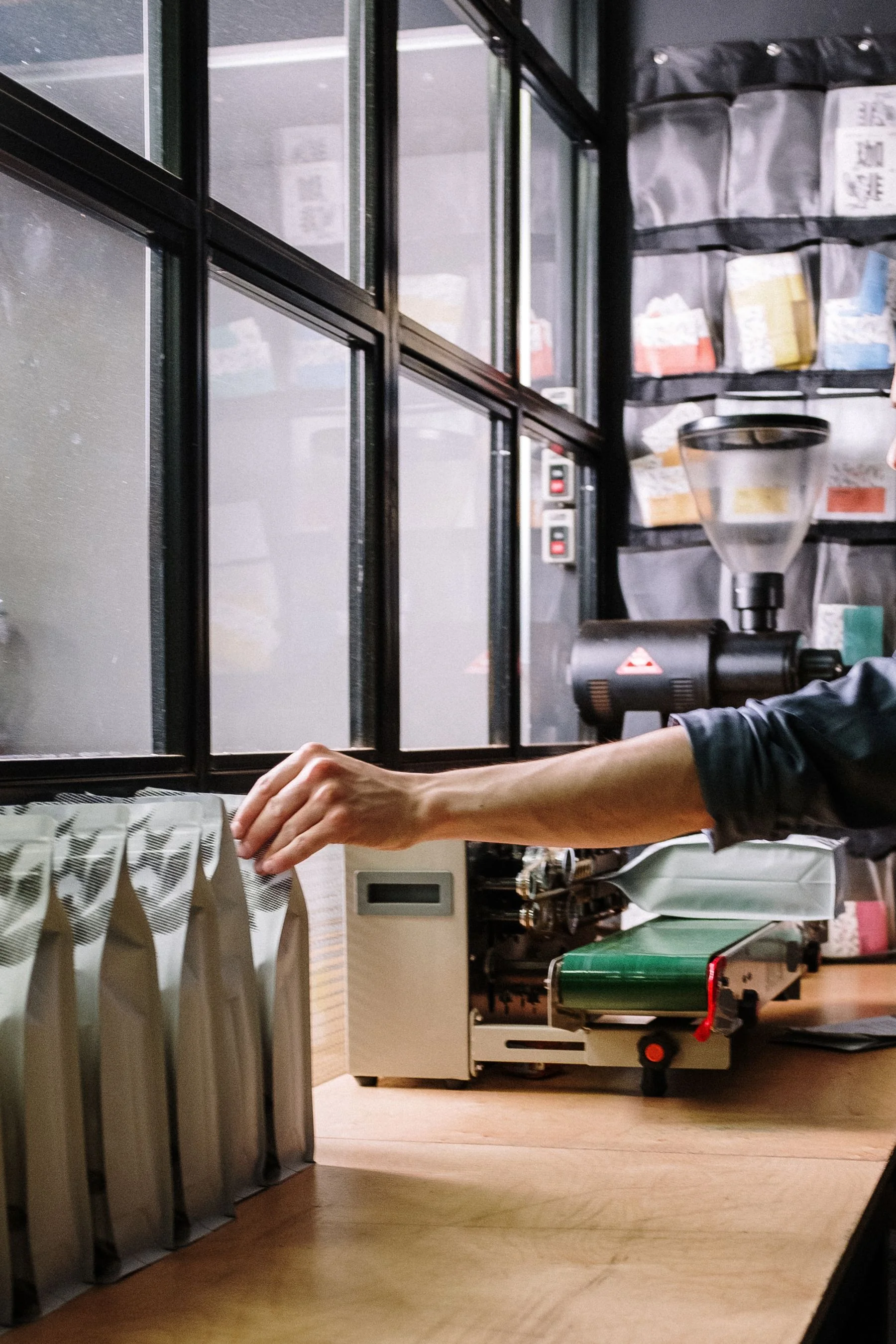 Người thợ đóng gói túi cà phê trong xưởng — ảnh Pexels.