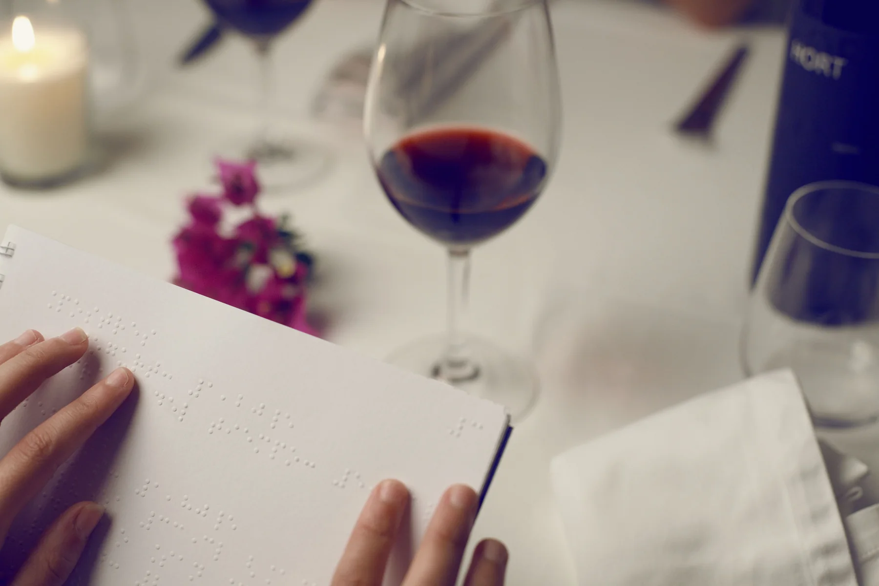 Menu Braille cầm tay trong không gian nhà hàng, ảnh tham khảo Pexels.